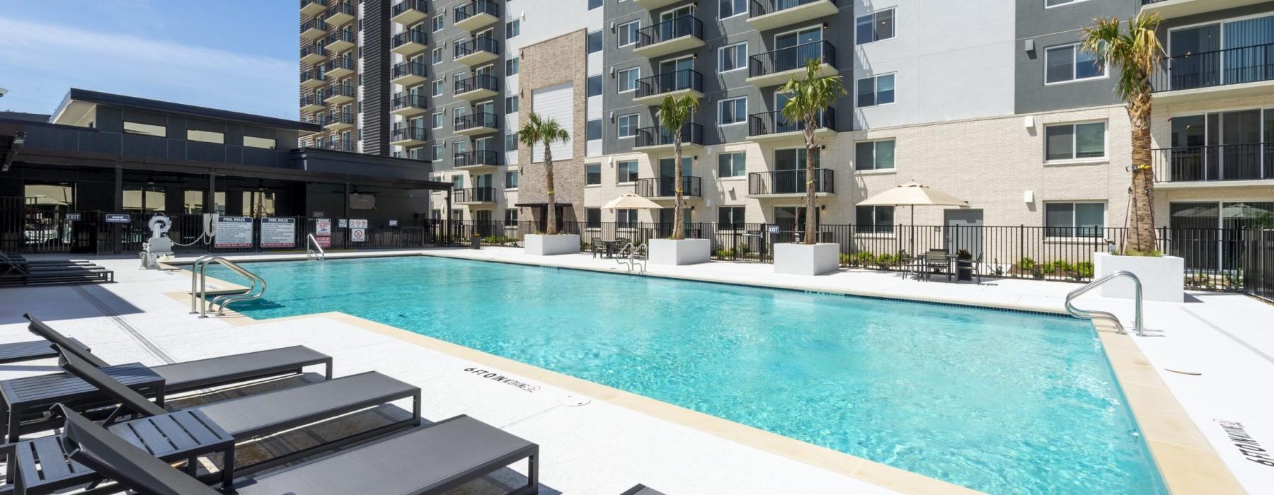 a pool with lounge chairs around it